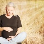 Pregnant woman sitting in a field